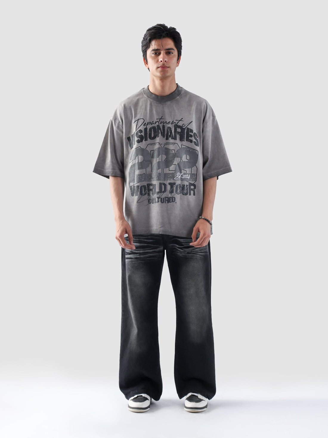 Female model leaning forward in Visionaries 222 t-shirt, styled with slick hair and a minimalistic streetwear backdrop.